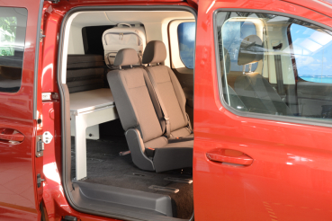 VanEssa Schlafsystem im VW Caddy 5 Maxi Ford Grand Tourneo Connect 3 Seitenansicht halbes Schlafboard aufgebaut Nutzung Sitzbank
