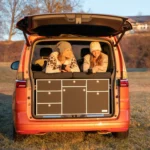 VanEssa rear kitchen carcass silver front black matt in VW T7 Multivan at sunrise with bed